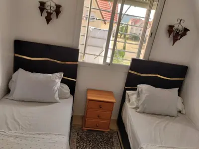 two beds in a small room with a window at Dar Yasmine 3 in Ifrane