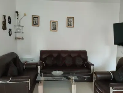 a living room with a leather couch and a table at Dar Yasmine 3 in Ifrane