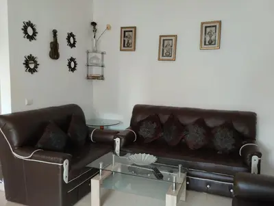 a living room with a leather couch and a glass table at Dar Yasmine 3 in Ifrane