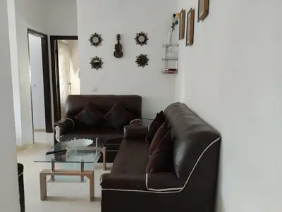 a living room with a leather couch and a table at Dar Yasmine 3 in Ifrane
