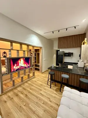 a living room with a fireplace in the wall at Dunes d or Stay in Er Rachidia
