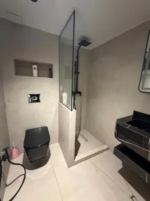 a bathroom with a black toilet and a sink at Dunes d or Stay in Er Rachidia