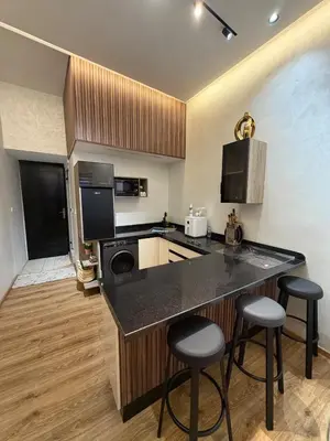 a kitchen with a counter and two bar stools at Dunes d or Stay in Er Rachidia