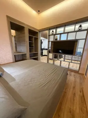 a bedroom with a large bed and a flat screen tv at Dunes d or Stay in Er Rachidia
