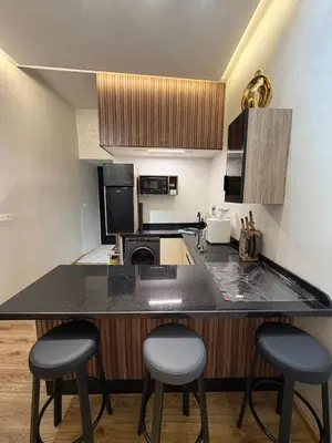 a kitchen with two bar stools and a counter top at Dunes d or Stay in Er Rachidia