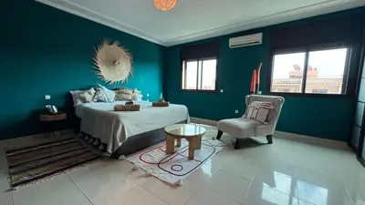 a blue bedroom with a bed and a chair at Rooftop au centre de Guéliz in Oulad Akkou