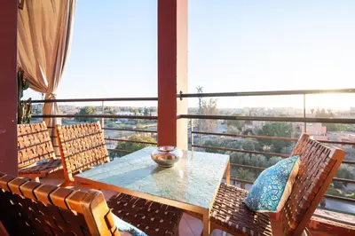 a table and chairs in a room with a large window at Rooftop au centre de Guéliz in Oulad Akkou