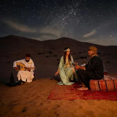 a group of three people sitting in the desert at night at Saba Queen Camp in Khamliya