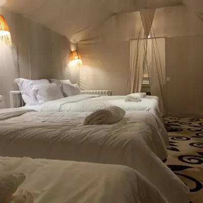 a woman laying on two beds in a hotel room at Sunny Luxury Camp in Merzouga