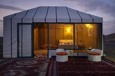 a tent with a table and chairs in a room at Chams Luxury Camp in Lac Yasmins