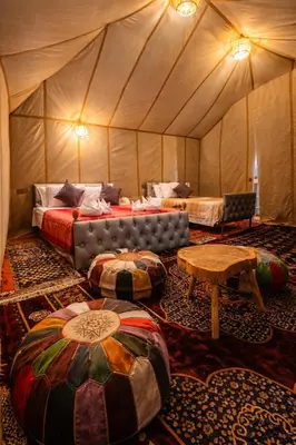 a room with two beds and a couch and tables at Chams Luxury Camp in Lac Yasmins