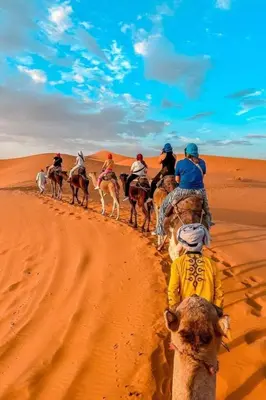a group of people riding horses in the desert at Moonrise Luxury Camp in Merzouga