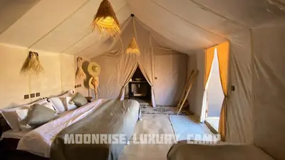 a bedroom with a bed in a tent at Moonrise Luxury Camp in Merzouga
