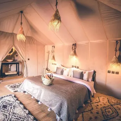 a bedroom with a bed in a tent at Moonrise Luxury Camp in Merzouga