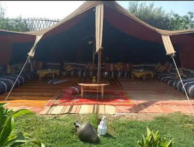 a tent with couches and a table in the grass at Riad Souiguia in Oulad Zbir