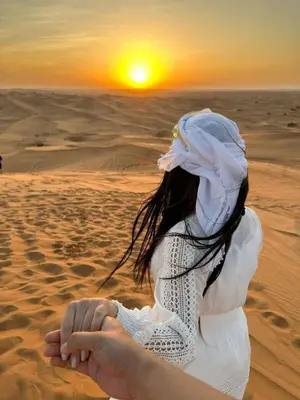 a woman in the desert holding her hand at Desert Luxe Camp in Merzouga