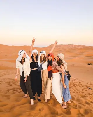 a group of women standing in the desert at Desert Luxe Camp in Merzouga