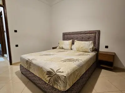 a bedroom with a large bed with a bed frame at Dar Jawhara in Oulad Akkou