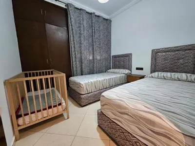 a bedroom with two beds and a crib in it at Dar Jawhara in Oulad Akkou