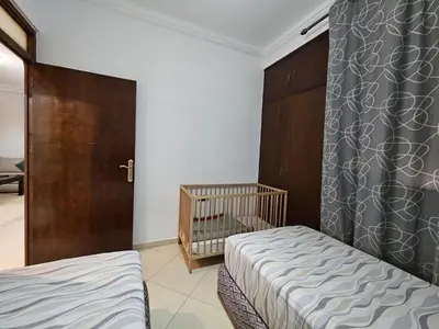 a small bedroom with two beds and a crib at Dar Jawhara in Oulad Akkou