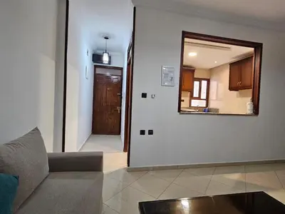 a living room with a couch and a mirror at Dar Jawhara in Oulad Akkou