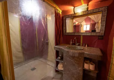 a bathroom with a shower and a sink and a mirror at Dunes Light Luxury camp in Merzouga