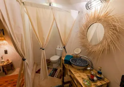a bathroom with a mirror and a toilet in a room at Dunes Light Luxury camp in Merzouga