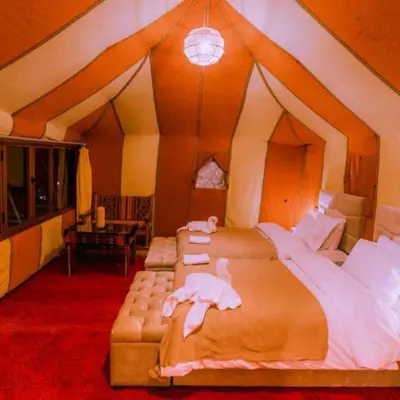 a bedroom with two beds in a tent at Erg Palace Luxury Camp in Merzouga