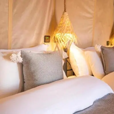 a bedroom with two beds with pillows and a lamp at Erg Palace Luxury Camp in Merzouga