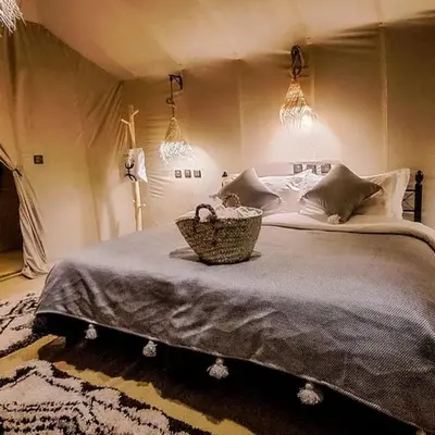 a bedroom with a bed with a basket on it at Erg Palace Luxury Camp in Merzouga