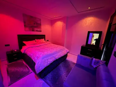a pink bedroom with a bed and a mirror at Lamoulian stay in Fès