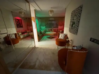 a living room with orange chairs and a green room at Lamoulian stay in Fès