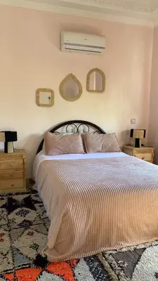 a bedroom with a bed with two night stands and two mirrors at Villa ourika in Aghmat
