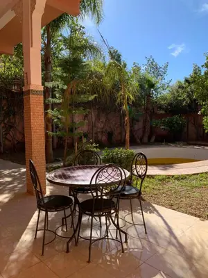 a table and four chairs sitting around a patio at Villa ourika in Aghmat