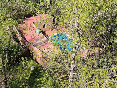 a red car with a blue in the trees at Ouberge 'loassis house in Douar Azrou Melloul