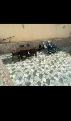 two tables and chairs sitting on a tiled floor at Appartement familial 110 m2 in Meknès
