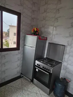a kitchen with a stove and a refrigerator at Appartement familial 110 m2 in Meknès