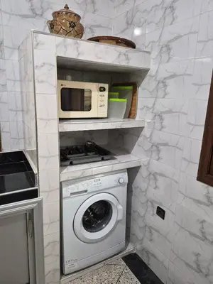 a kitchen with a washing machine and a microwave at Appartement familial 110 m2 in Meknès