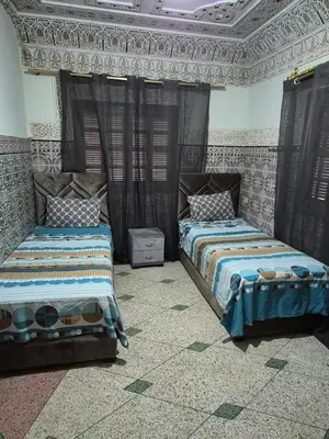 a bedroom with two beds and a ceiling at Appartement familial 110 m2 in Meknès