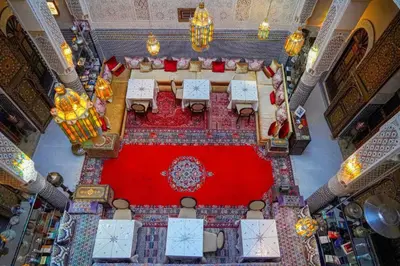 an overhead view of a dining room with a red carpet at Riad Fez social club in Fès