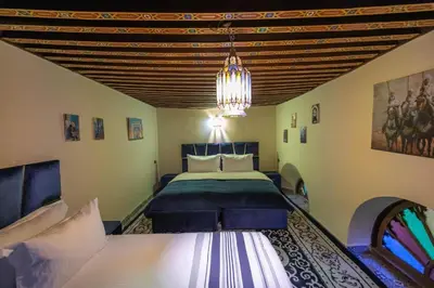 a bedroom with a king sized bed and a chandelier at Riad Fez social club in Fès