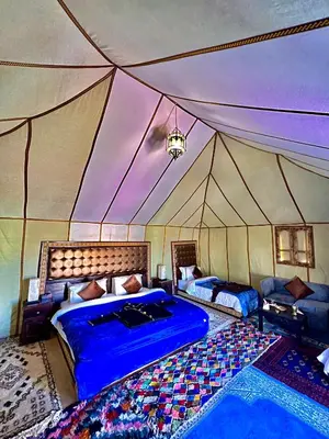 a bedroom with two beds in a tent at Desert Paradise Lodging in Merzouga