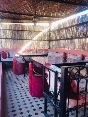 a room with two tables and a counter with chairs at Riad dar milouda in Fès