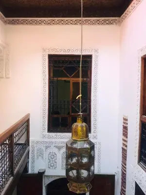 a chandelier hanging from a wall with a window at Riad dar milouda in Fès