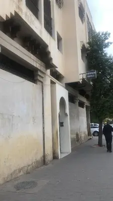 a man walking down a sidewalk next to a building at khamsin home in Oulad Akkou