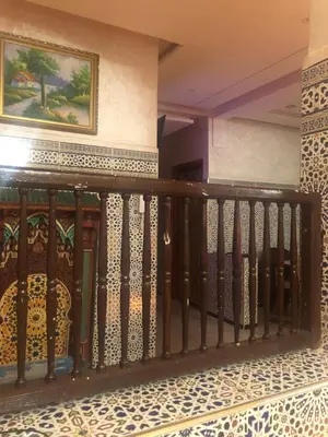 a balcony with a fence and a painting on the wall at khamsin home in Oulad Akkou
