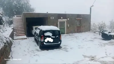 a car covered in snow in front of a house at Tigmi Nlkhir in Aït Irizane