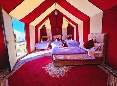 a room with three beds in a circus tent at Merzouga Luxury Camp & Desert Activities in Merzouga