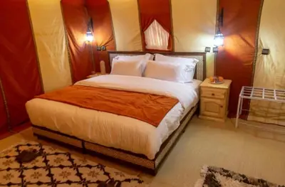 a bedroom with a large bed in a room at Merzouga Luxury Camp & Desert Activities in Merzouga