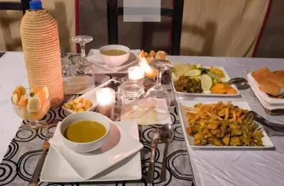 a table with two plates of food and a cup of tea at Merzouga Luxury Camp & Desert Activities in Merzouga